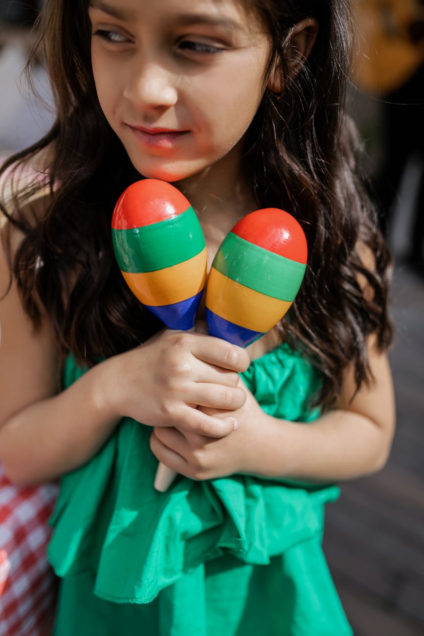 girl in green dress holding maracas